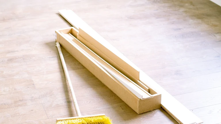 Baureinigung in Feucht – Symbolfoto: Besen und Baumaterial in einem Innenraum während der Renovierung.